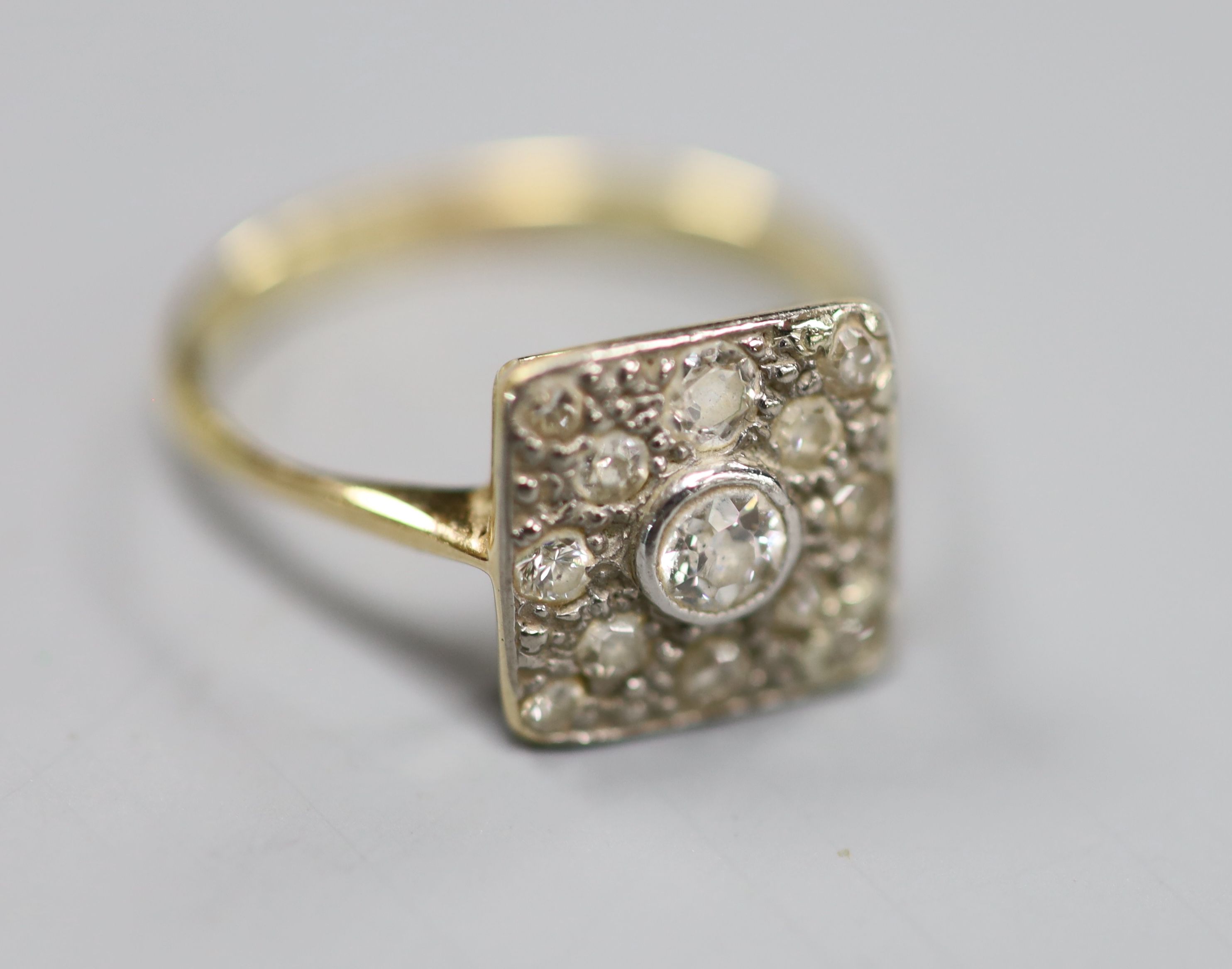 A 1940s yellow metal and diamond set square cluster ring, size M, gross 2.8 grams.